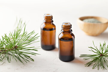 Pine essential oil in small glass bottles. Soft focus.