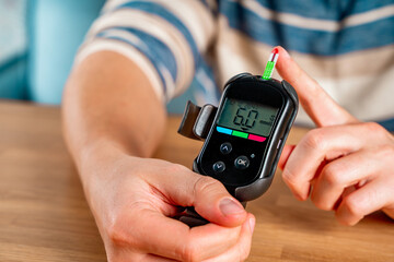 Measuring blood glucose levels from a finger. Sugar control, the concept of diabetes