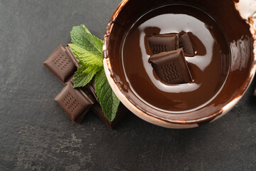 Hot chocolate in bowl, top view with mint leaves. Chocolate paste in a cup and mints leaf. Recipe Cooking handmade chocolate bar, dessert, candies. Confectionery covered with chocolate topping