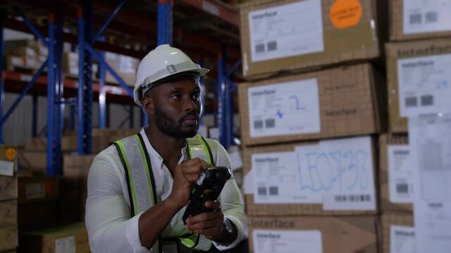 Business concept of 4k Resolution. African man checking goods in warehouse.