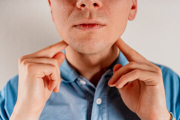  A man checks the lymph nodes on his neck.