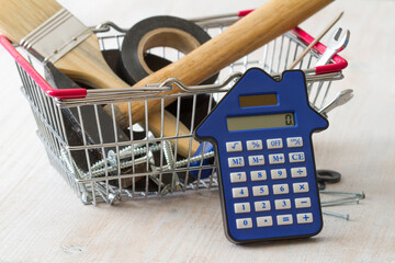 DIY tools in shopping basket with calculator, home construction and renovation costs concept