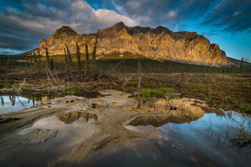 Sukakpak Mountain in the central Brooks Range of northern Alaska is reflected in a small tundra pond. 