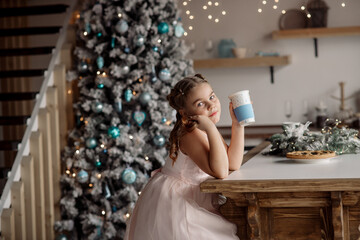 Portrait of a cute girl dreaming about gifts under the Christmas tree. Concept for family celebrating new year and christmas at home during coronavirus pandemic