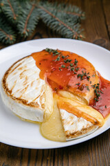 Brie cheese grilled on a wooden table. Christmas dinner
