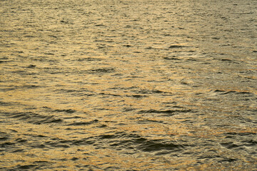 Ripples on the surface of the water at sunset as a background.