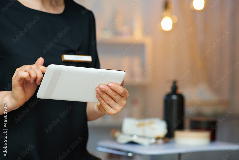 Wall mural female employee in beauty salon using tablet pc