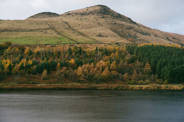 Breathtaking forest view on a mountain slope and a lake - autumnal landscape.