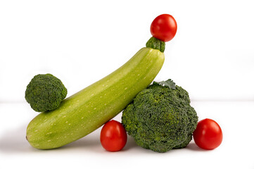 Vegetable art composition. Abstract balancing design of zucchini, broccoli and tomatoes. Copy space. Modern visual art, minimal design, healthy eating concept.