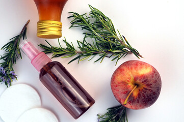 Face toner for acne skin in a bottle, fresh rosemary branches, apple cider vinegar bottle on white...