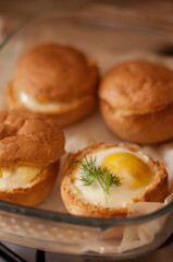 fried eggs in buns on a glass baking sheet with blurred edges