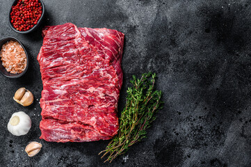Raw fresh marble beef brisket meat with herbs. Black background. Top view. Copy space