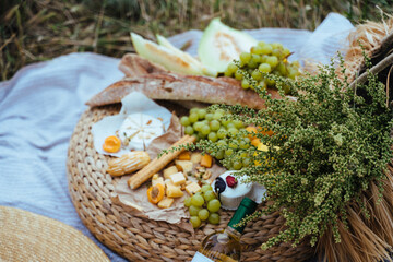 Wine and assorted products for the summer picnic are served on a blanket outdoors