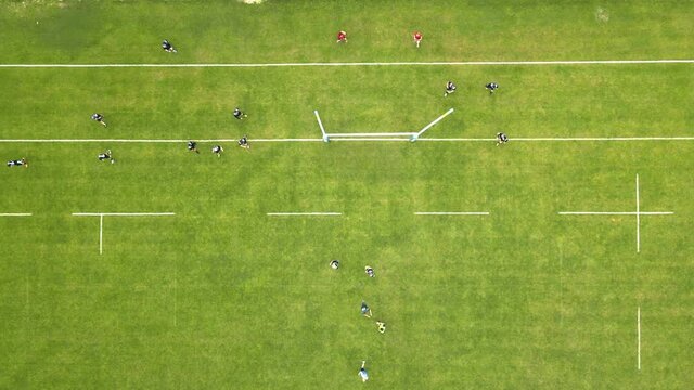 Aerial view Rugby players fight for the ball. Playing rugby on a large green field.