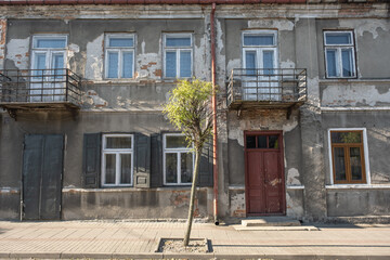 Zniszczona fasada kamienicy w zaniedbanym miasteczku © Gregory Shot