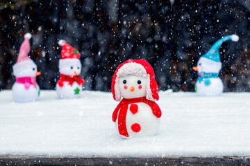 Two snowmen in the forest during a snowfall. Christmas and New Year card