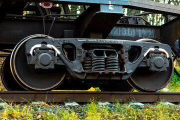 Part of a freight car with massive wheels during the movement of the train on the track