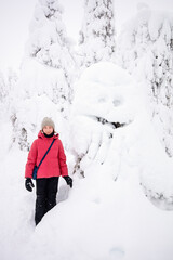 Fototapeta premium Cute girl in winter forest in Finland