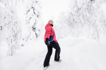Fototapeta na wymiar Cute girl in winter forest in Finland