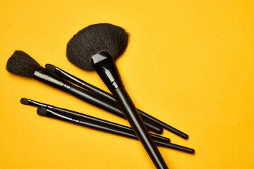 cosmetics mascara brushes decoration accessories yellow background