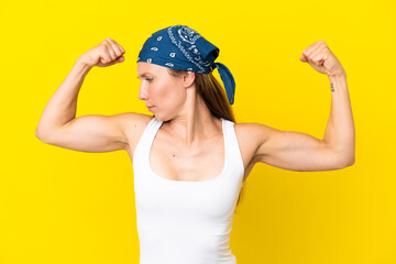 Young English woman isolated on yellow background doing strong gesture