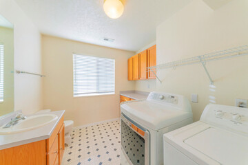 Laundry and bathroom combination interior with patterned tiles and shelving units