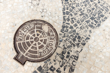 Fototapeta na wymiar Detail of the sewer cover and sidewalk on Copacabana beach in Rio de Janeiro, Brazil