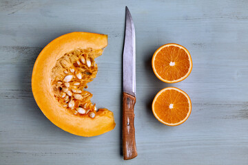 Fresh organic pumpkin slice, cut oranges and a knife