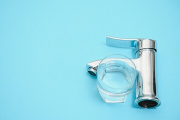 Single handle water tap on light blue background, closeup