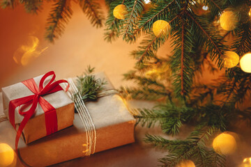 beautifully wrapped in craft paper gift, tied with rope and red ribbon, christmas tree with garland