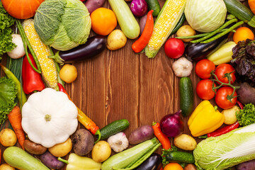 Assortment of the fresh ripe vegetables on wooden background with space for text. A collection of fresh and delicious vegetables. Healthy organic food concept