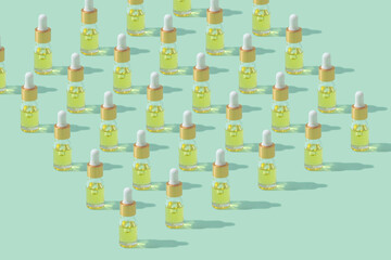 Dropper bottles pattern with cosmetic oil or serum with pipette on mint background copy space