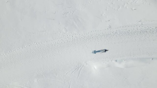 Aerial Top view of a participant in a biathlon race. Athlete overcomes the distance on skis.