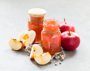 Fruit dessert, Apple jam in glass jars on a linen napkin on a light gray background in rustic style