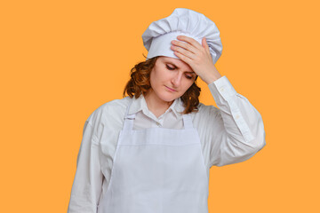 Sick woman chef is sad with her hands to her sore head on studio background, mockup copy space
