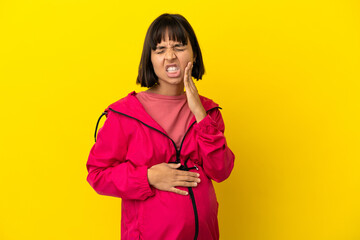 Young pregnant woman over isolated yellow background with toothache