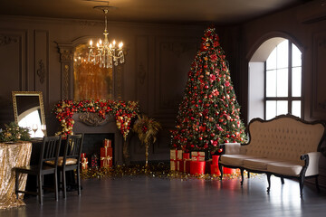 Interior of luxury dark living room with fireplace, comfortable sofa and chandelier decorated with Christmas tree and gifts