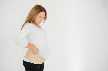 Woman puts on a bandage for pregnant women. Close-up.