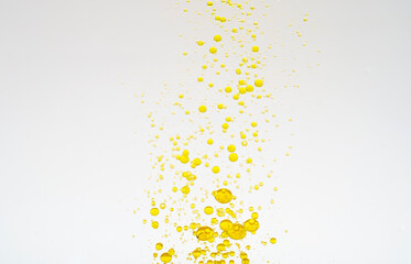 Oil drops isolated. Golden liquid drops of oil in water on a white background. Food or cosmetics...