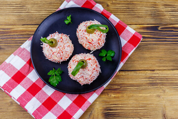 Appetizer of crab-cheese balls made in a shape of Christmas baubles on wooden table. Top view