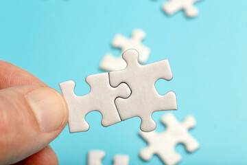  Puzzle pieces are connected. White puzzle pieces in hand on a blue background. Business, partner,...