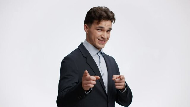 Young positive businessman pointing to camera with both hands, inviting to work with him at successful company