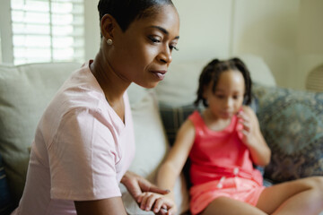 Mother and daughter sitting on sofa