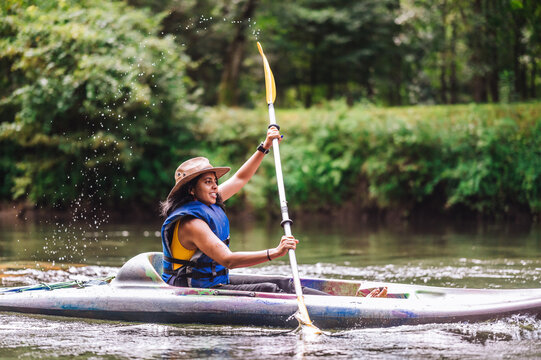 Woman in hat kayaking on river&nbsp;