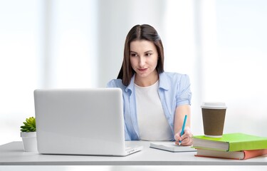 Positive smart young female freelancer or a student with laptop