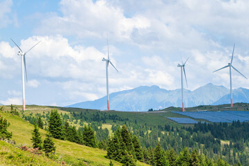 green energy, solar panels and wind power station on mountain