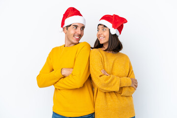 Young mixed race couple celebrating Christmas isolated on white background looking over the shoulder with a smile