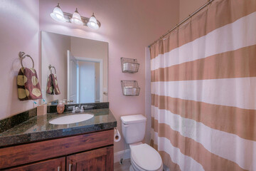 Small bathroom interior with dark wood vanity sink and black granite countertop