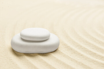Fototapeta na wymiar Spa stones on light sand. Zen concept
