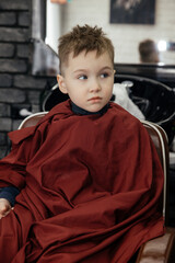 Close-up portrait of a beautiful white boy in a barbershop. the concept of stylish and modern children's hairstyles